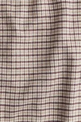 Pantalón de corte relajado confeccionado en franela de algodón suave, con diseño a cuadros. Presenta cintura elástica con cordón ajustable, cierre decorativo y bolsillos laterales al bies.