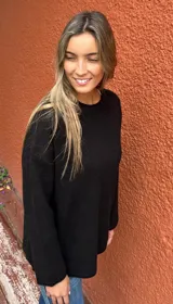 Sweater de tejido de punto color negro, con cuello redondo, mangas largas y corte holgado.
