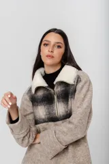 Buzo marrón de lana con mangas rectas, largo medio y cuello con cierre. Aplique de corderito azul en el cuello. Buzo amplio con diseño a cuadros en la parte superior.