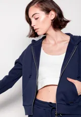 Canguro negro con cierre metálico, cordones y capucha. Tiene bolsillos en el frente.