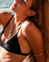 Collar con dije de bronce macizo con forma orgánica irregular, similar a un coral, suspendido de un cordón negro de seda natural anudado.