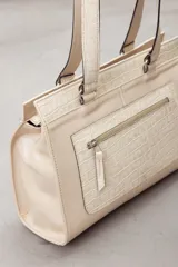 Cartera de cuero marrón de tamaño medio con diseño estructurado, que combina cuero liso y un panel frontal texturizado tipo cocodrilo con bolsillo exterior con cierre. Cuenta con doble asa de hombro y costuras visibles de contraste.