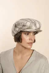 Boina con visera y orejeras, con estampado a cuadros en tonos beige y blanco.