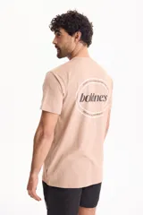 Remera color tostado de manga corta y corte regular fit, con estampa en la espalda dentro de un óvalo con la inscripción "boldness".