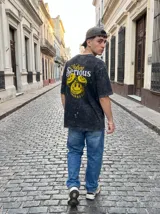 Remera negra con efecto lavado y estampado de tres caras sonrientes amarillas y texto "Nothing Serious". Corte oversize.