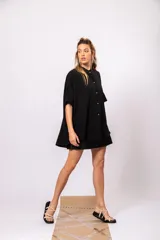 Camisa oversize de manga corta, color negro, con cuello mao y cierre frontal de botones dorados.