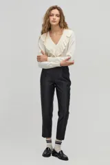 Sweater color crema de tejido de punto con lurex, escote en V con volados y mangas largas.