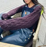 Buzo corto tejido a crochet en lana color marrón oscuro, con capucha.