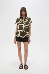 Blusa holgada de manga corta, con escote en V y estampado abstracto en tonos verde oliva y blanco.