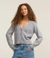 Cardigan corto gris de punto fino, con escote en V, cierre frontal con botones y apliques de pedrería formando corazones.
