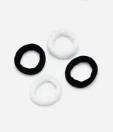 Set de cuatro gomitas de pelo gruesas, dos de color negro y dos de color blanco, con textura acanalada.