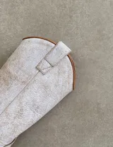 Botas de cuero color marrón y blanco con bordados negros, de estilo cowboy con taco bajo.