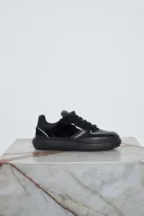 Championes blancos de cuero con cordones y apliques metálicos.