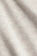 Top de punto interlock pesado con escote bote, manga larga con hombros caídos y diseño de bajo asimétrico.