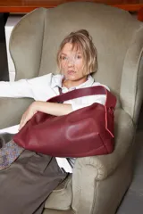 Cartera negra de cuero granulado, con cierre metálico y doble correa regulable y desmontable. Cuenta con un bolsillo interior con cierre y otro para el celular.