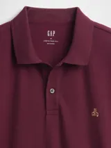 Polo de manga corta color verde oscuro, con cuello clásico, cierre frontal de dos botones y logo del oso Brannan bordado en el pecho.