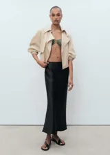 Falda midi evasé de tejido satinado color negro, con tiro medio y cintura elástica sin cierre.