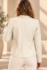 Campera de cuero ovino color marfil, con cuello con solapas, cierre frontal y bolsillos laterales.