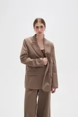 Blazer de corte holgado con diseño de rayas verticales, cuello solapa y cierre frontal con un botón. Cuenta con bolsillos laterales con solapa.