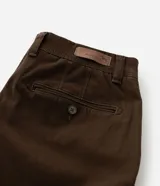 Bermuda masculina slim confeccionada en sarga de algodón con elastano, color beige, con bolsillos laterales tipo chino, bolsillos traseros embutidos con botón, trabillas en la cintura y cierre frontal con botón y cremallera.