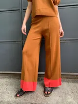 Pantalón marrón de algodón con corte palazzo y detalle de puños color coral.