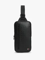 Cartera tipo sling Tommy Hilfiger de color negro, con diseño texturizado, bolsillo frontal con cierre y correa ajustable.