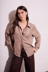 Camisa color marrón claro de gamuza vegana, corte oversize, con cuello clásico, cierre frontal con botones y mangas largas.