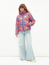 Campera puffer corta con estampado abstracto en tonos verde, naranja y azul. Tiene cuello alto, cierre frontal con cremallera y bolsillos laterales.