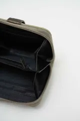 Billetera compacta de gamuza color beige con detalle de solapa central en cuero sintético marrón oscuro y cierre perimetral.