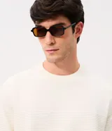 Suéter de punto para hombre en color marrón chocolate, con cuello redondo y mangas largas. Presenta un diseño de canalé texturizado en la parte inferior y las mangas, contrastando con una sección lisa en el pecho.