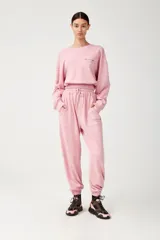 Pantalón de jogging rosado con cintura elastizada y cordón de ajuste, bolsillos laterales con estampado y puños elastizados.