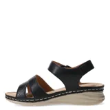 Sandalias de mujer con tiras de cuero sintético negro, una de ellas con textura grabada, cierre con velcro en el tobillo y suela de plataforma baja en color beige con costuras decorativas.