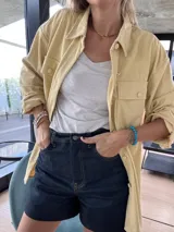 Sobrecamisa de pana color amarillo, con cuello clásico, cierre frontal de botones y bolsillos delanteros con solapa.