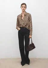 Camisa fluida de corte recto con estampado animal print de leopardo, cuello camisero, manga larga y cierre frontal con botones.