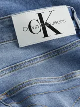 Pantalón de jean celeste de corte slim fit, tiro bajo, con bragueta con cremallera y diseño de cinco bolsillos.