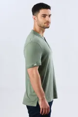 Remera polo de manga corta en color azul melange, con cuello camisero, cierre frontal de dos botones y pequeño bordado en el pecho.
