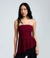 Blusa peplum bordó sin breteles con diseño asimétrico y costuras estructuradas en bengalina.