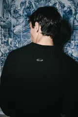 Sweater de tejido acanalado en color negro, con cuello redondo y logo bordado en el pecho.