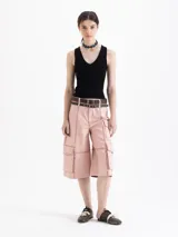 Top negro de tejido frío, ajustado al cuerpo y largo por debajo de la cintura.