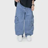 Pantalón cargo de jean en color azul lavado, con corte ultra baggy y diseño de costuras diagonales en las piernas. Cuenta con bolsillos laterales tipo cargo con solapa.