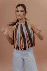 Musculosa de algodón con cuello redondo, sin mangas y diseño abullonado en la parte inferior. Presenta un estampado de rayas verticales en tonos marrones, naranjas, celestes y negros.