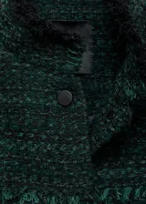 Chaqueta de tweed en color verde oscuro, con diseño corto y recto. Presenta cuello alto, cierre frontal con botones, mangas largas y dos bolsillos de solapa con botón en el frente. Se caracteriza por sus terminaciones deshilachadas y costuras decorativas.