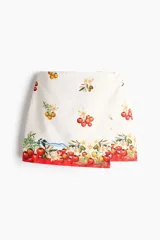 Minifalda cruzada de algodón con estampado de tomates y flores, corte evasé y diseño asimétrico.