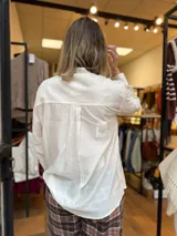 Camisa blanca de diseño liso con cuello mao y un bolsillo delantero decorado con detalles en broderie.