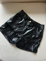Short negro de cuero sintético con flecos.