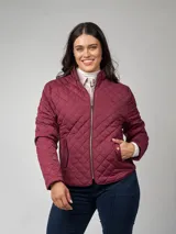 Campera capitoneada color borgoña, de nylon, manga larga, con entalle elástico en laterales, cuello mao y cierre frontal con cremallera. Bolsillos frontales con tapa y broche. Detalle de presilla desmontable en el contorno de cuello.