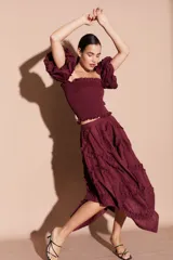 Top corto color bordó con escote cuadrado, cuerpo fruncido y mangas abullonadas con volados.