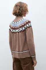 Polera de tejido de punto en color tostado, con diseño de estampado geométrico tipo nórdico en la zona del cuello, hombros y puños. Presenta cuello alto acanalado y mangas largas.