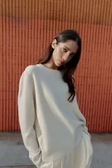Jersey de punto liso con cuello redondo y manga larga, con acabados en rib en puños y ruedo.