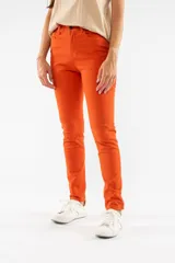 Pantalón de corte slim skinny, color naranja vibrante, con cierre de botón y cremallera frontal, y bolsillos laterales.